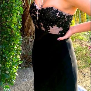 Formal black dress, lace on the chest, and a slit